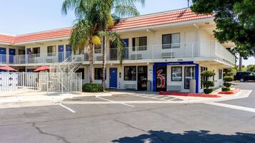 A motel with a red-tiled roof, a blue entrance, and a '5' rating sign.