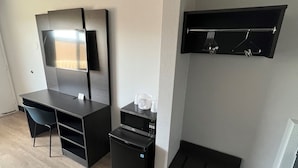 A compact, modern room with a built-in desk, a flat-screen TV, a microwave, and a small refrigerator. - Motel 6 Eureka, CA – Redwood Coast (Eureka)