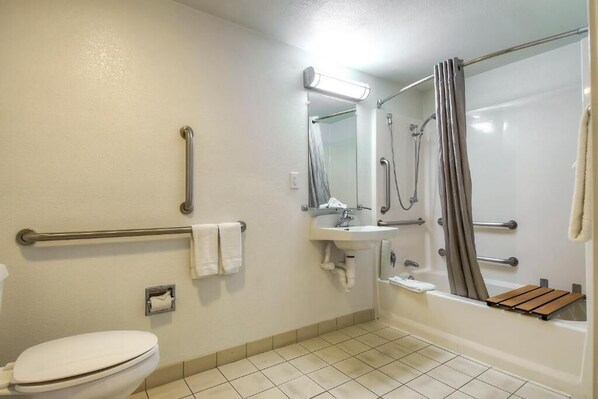 A bathroom with a toilet, sink, shower, and grab bars. - Motel 6 Carlsbad, CA - Near Legoland (Carlsbad)