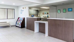 A reception area with a counter, a bulletin board, and a clock on the wall.