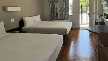 Habitación de hotel con dos camas, una mesita y una silla.