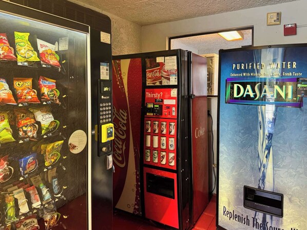 A vending machine with snacks and a Coca-Cola machine.