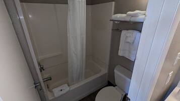 A bathroom with a shower, toilet, and a towel rack.