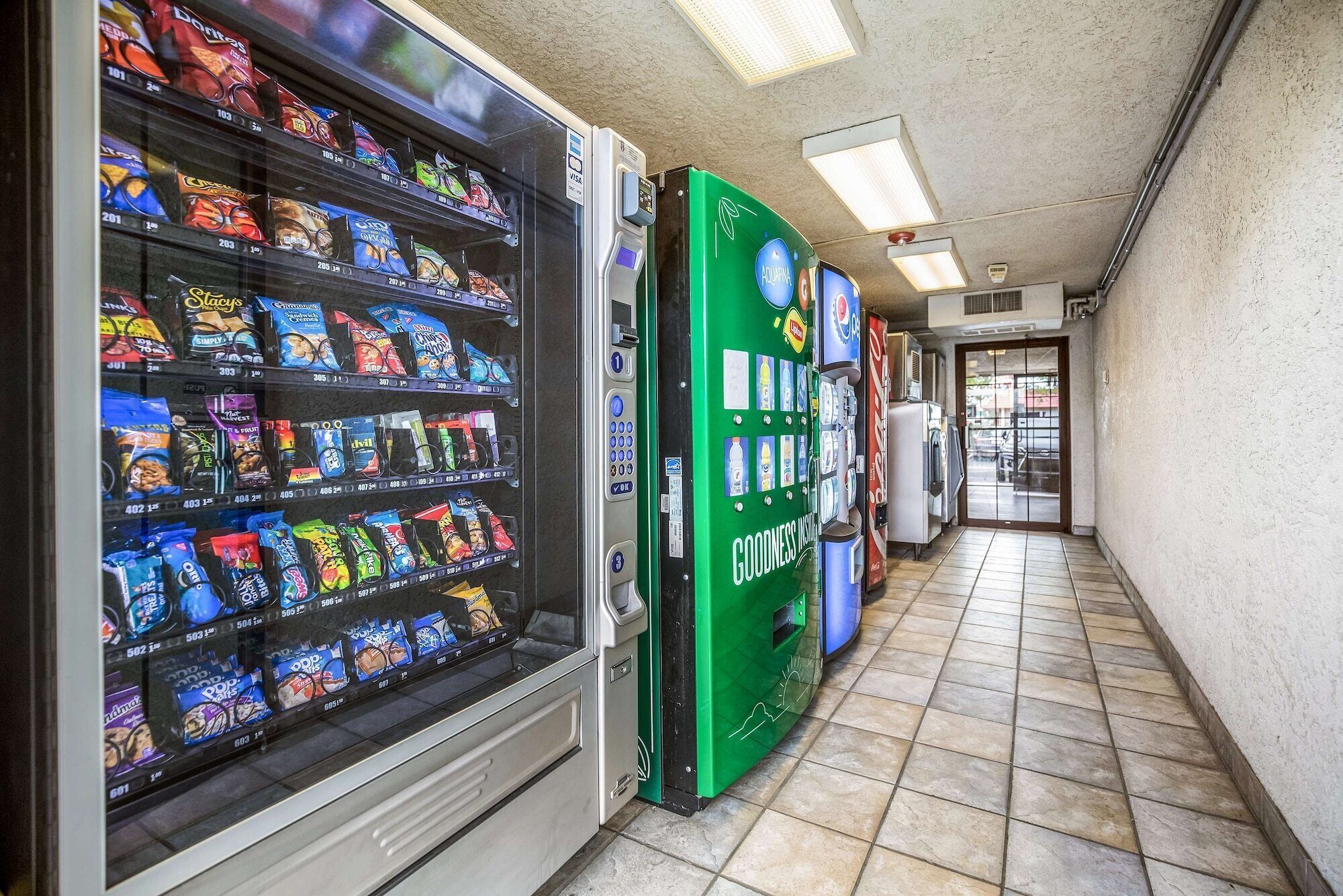 Et automatområde med snacks og en grøn automat med påskriften "GOODNESS".