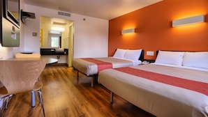 A hotel room with two beds, a wooden floor, a desk with a chair, and a bathroom visible through an open door. - Super 8 by Wyndham Petaluma (Petaluma)