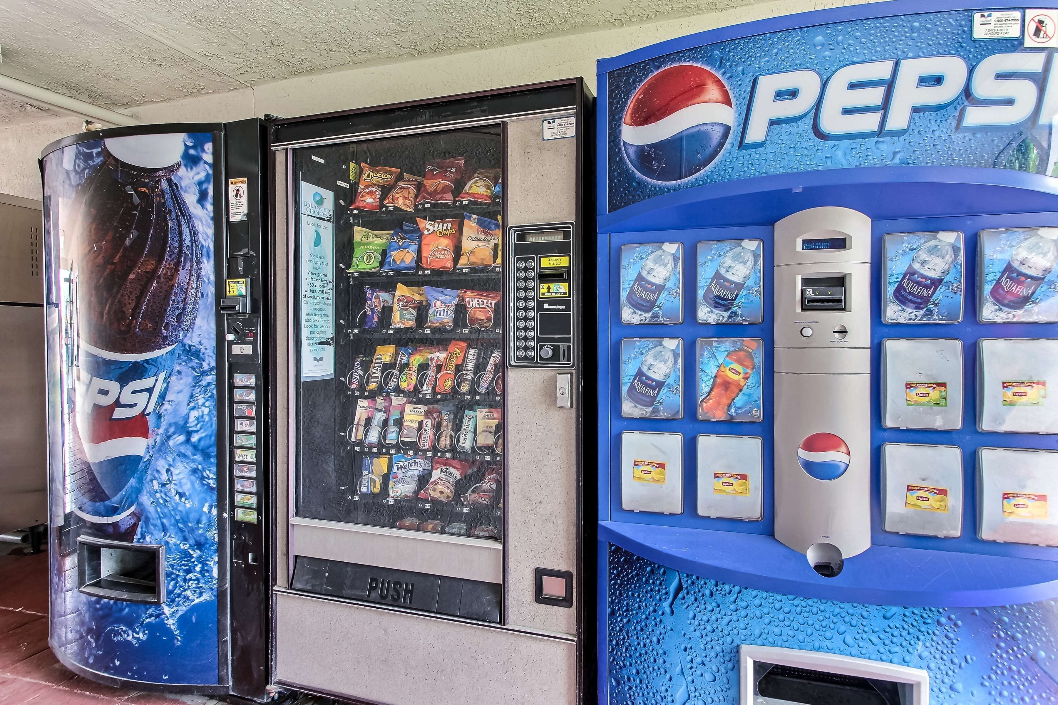Een automaat met een Pepsi logo en een drukknoop.