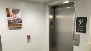 Ein Aufzug mit einem Hinweis, im Brandfall die Treppe zu benutzen.