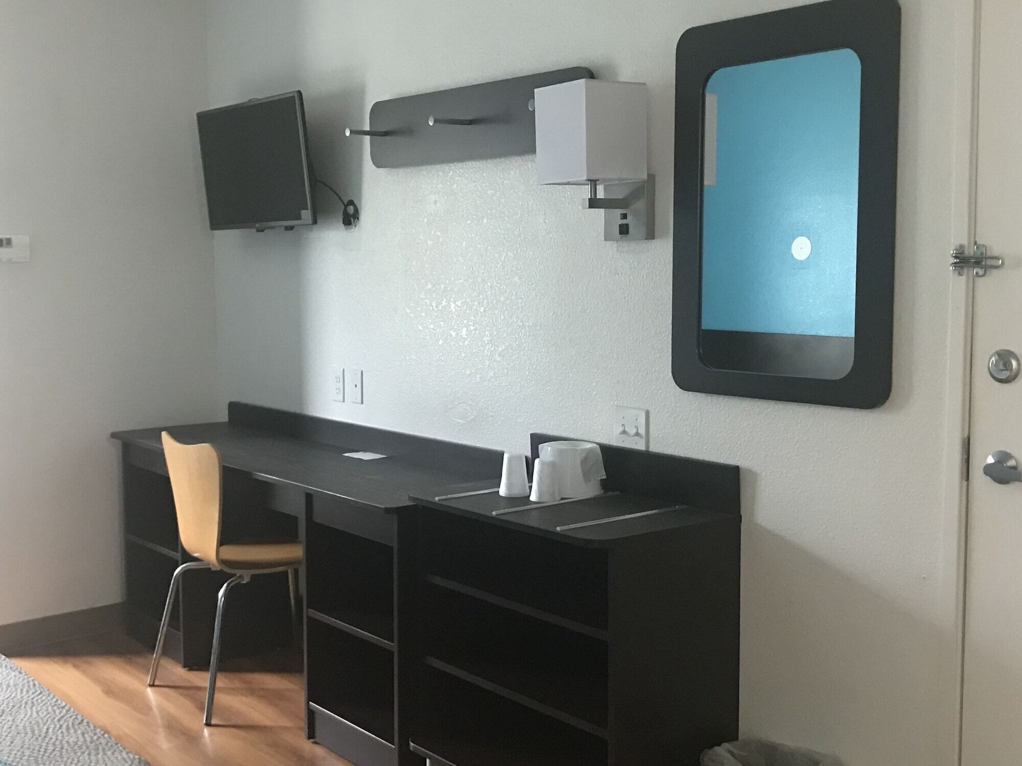 A modern room with a desk, chair, and a mounted TV.