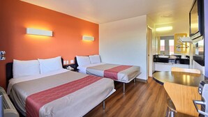 A hotel room with two beds, a wooden dining table, and a kitchenette. - Motel 6 Laredo, TX - South (Laredo)