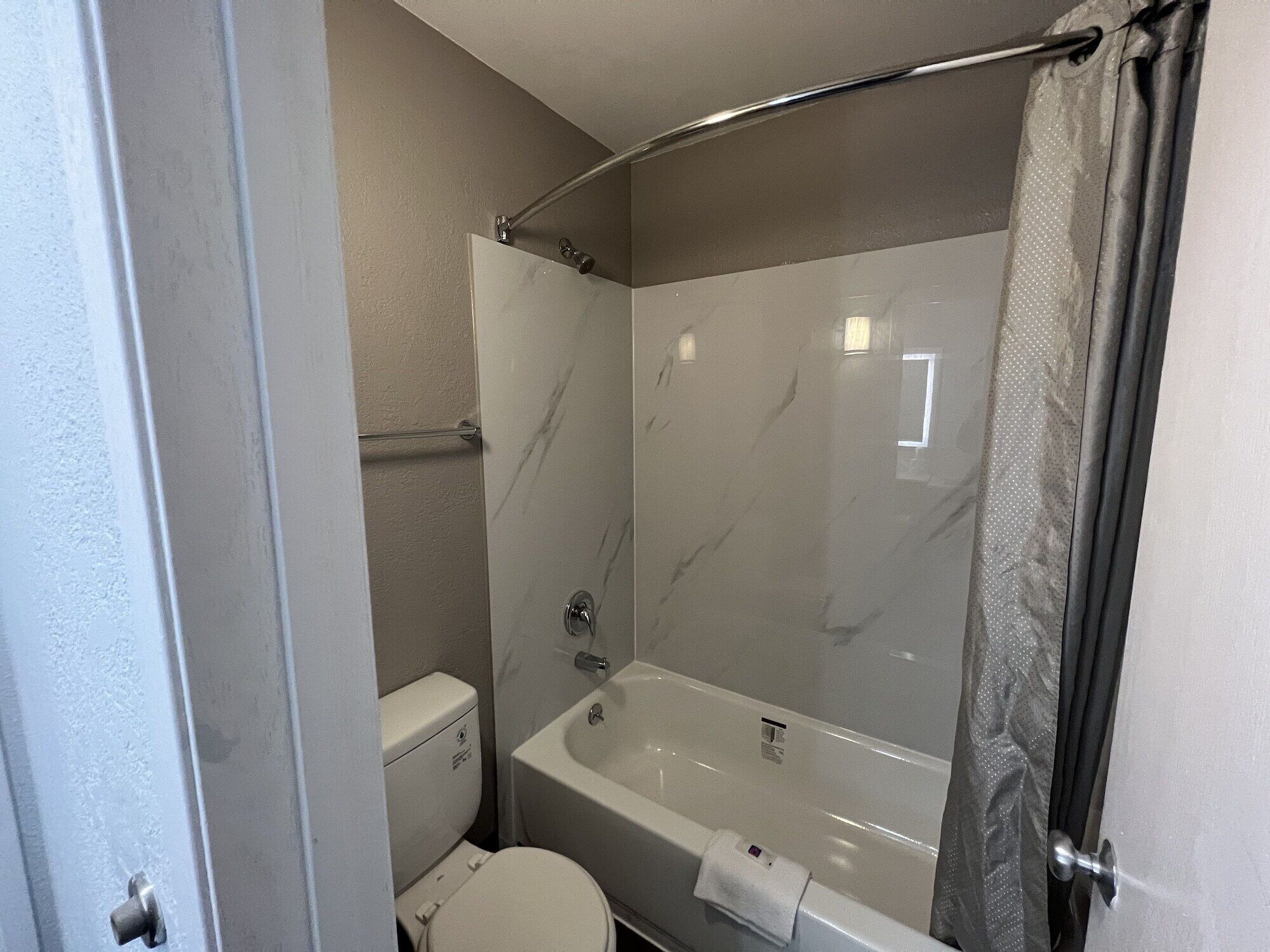 A bathroom with a shower, toilet, and bathtub.