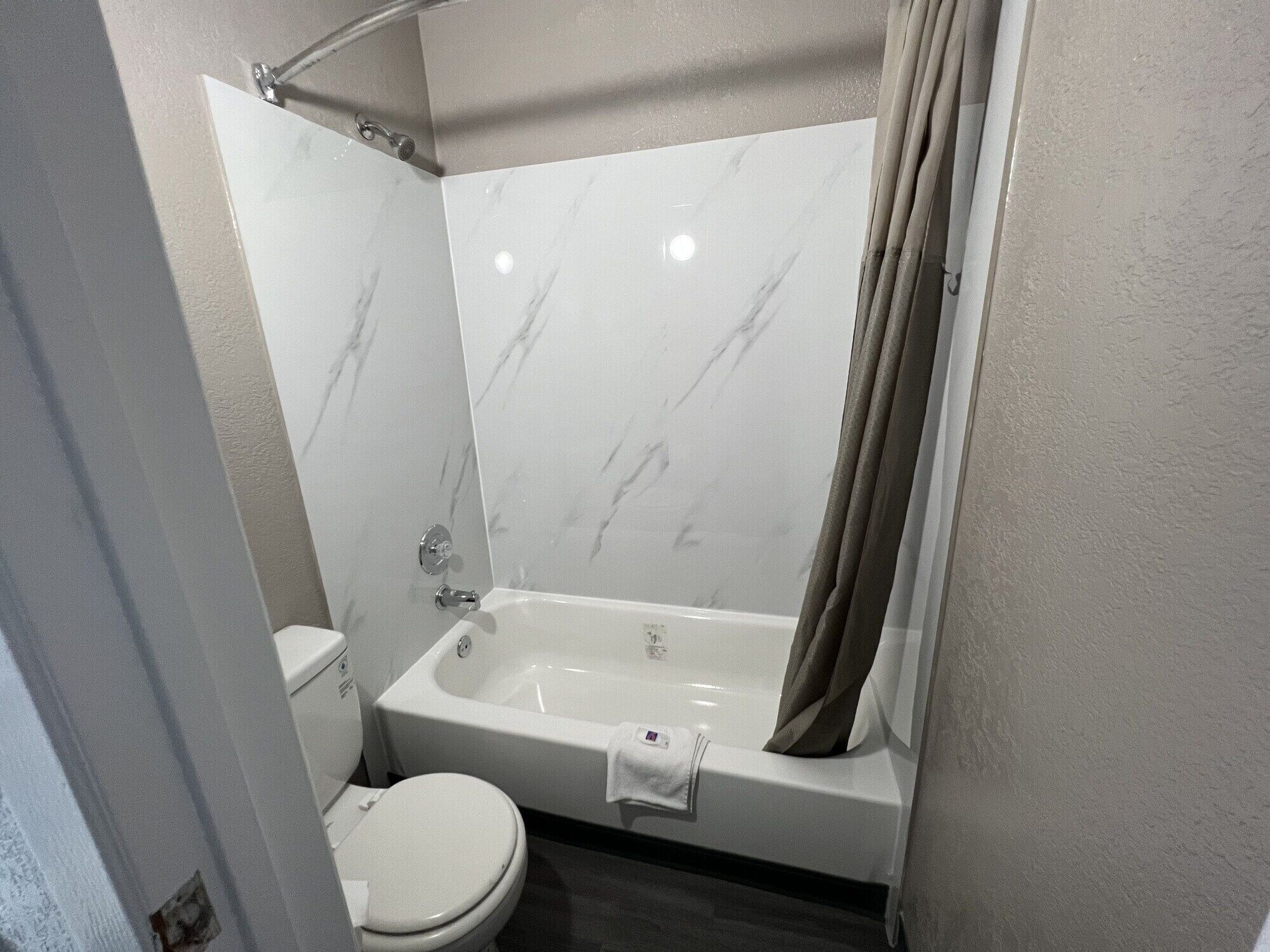 A bathroom with a toilet, a bathtub, and a shower curtain.