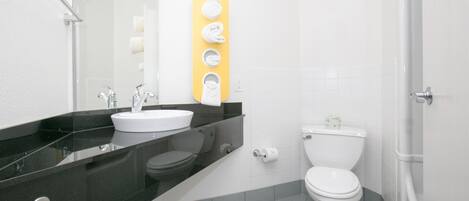 Een moderne badkamer met een zwart aanrecht, een wit wastafel en een toilet. Aan de muur bevindt zich een gele handdoekhouder.