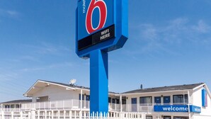 A motel sign with a '6' logo and a 'WIFI HERE' sign. - Motel 6 Fort Worth, TX - North (Fort Worth)