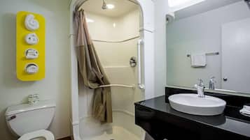 Et badeværelse med toilet, bruser og håndvask.