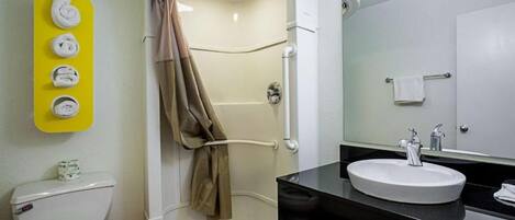 Une salle de bain avec des toilettes, une douche et un lavabo.