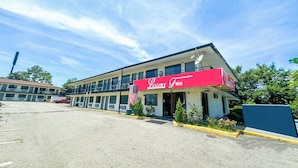 A two-story building with a red awning labeled "Luxury Inn." - Luxury Inn by OYO Albany (Albany)