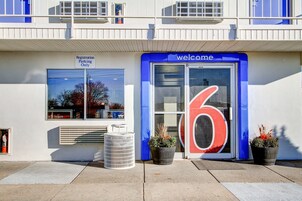 A building with a 'Registration Parking Only' sign, a 'Welcome' sign, and a large number '6' on the door.
