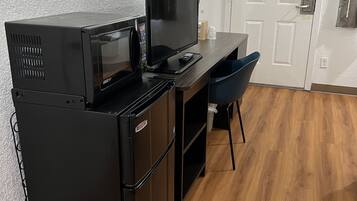 A compact kitchenette with a refrigerator, microwave, and a small countertop.