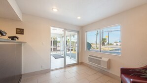 A hotel lobby with a reception desk, a glass door entrance, and a large window offering a view of the outside. - Red Roof Inn San Antonio E – Frost Bank Center (San Antonio)