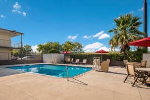 Een seizoensgebonden buitenzwembad en parasols bij het zwembad