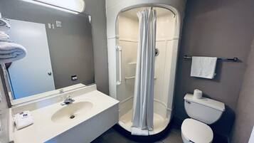 Een bad/douchecombinatie, een regendouche, handdoeken