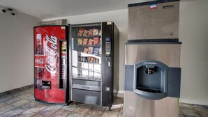 Ein Getränkeautomat mit Coca-Cola-Logo, einem Scotsman-Eisspender und verschiedenen Snacks.