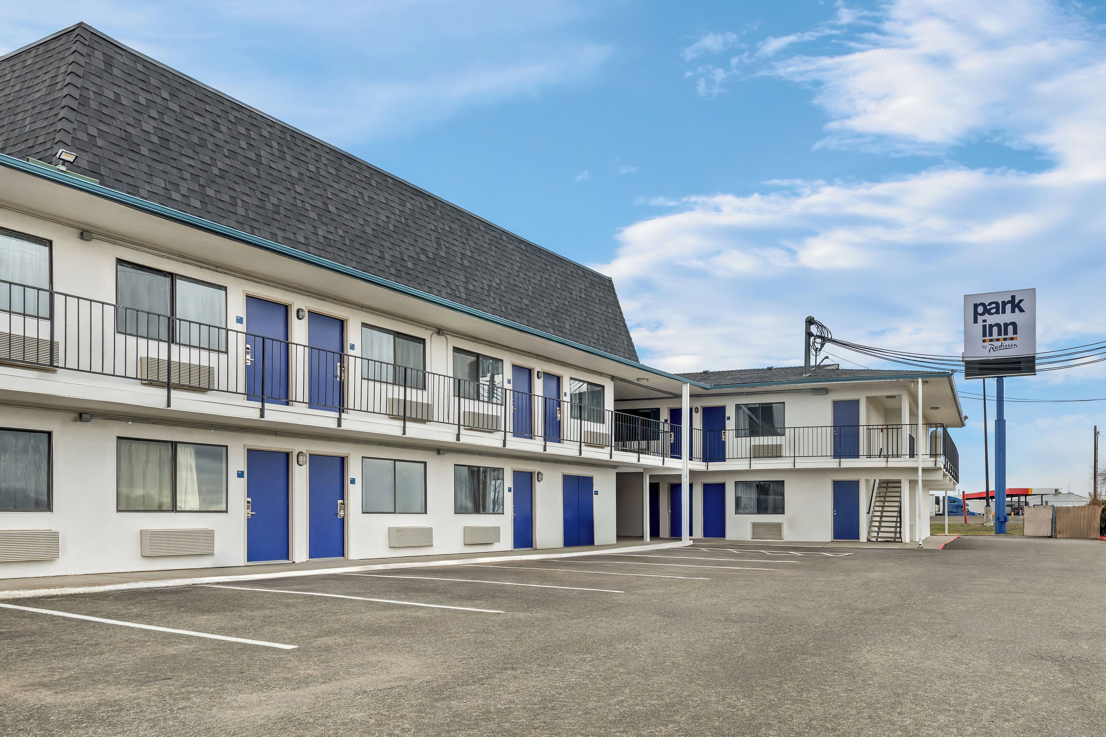 A multi-story motel with a parking lot, featuring a 'Park Inn' sign.