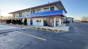A two-story building with a 'Welcome' sign, a parking lot, and a number '6' on the entrance. - Motel 6 Janesville, WI (Janesville)