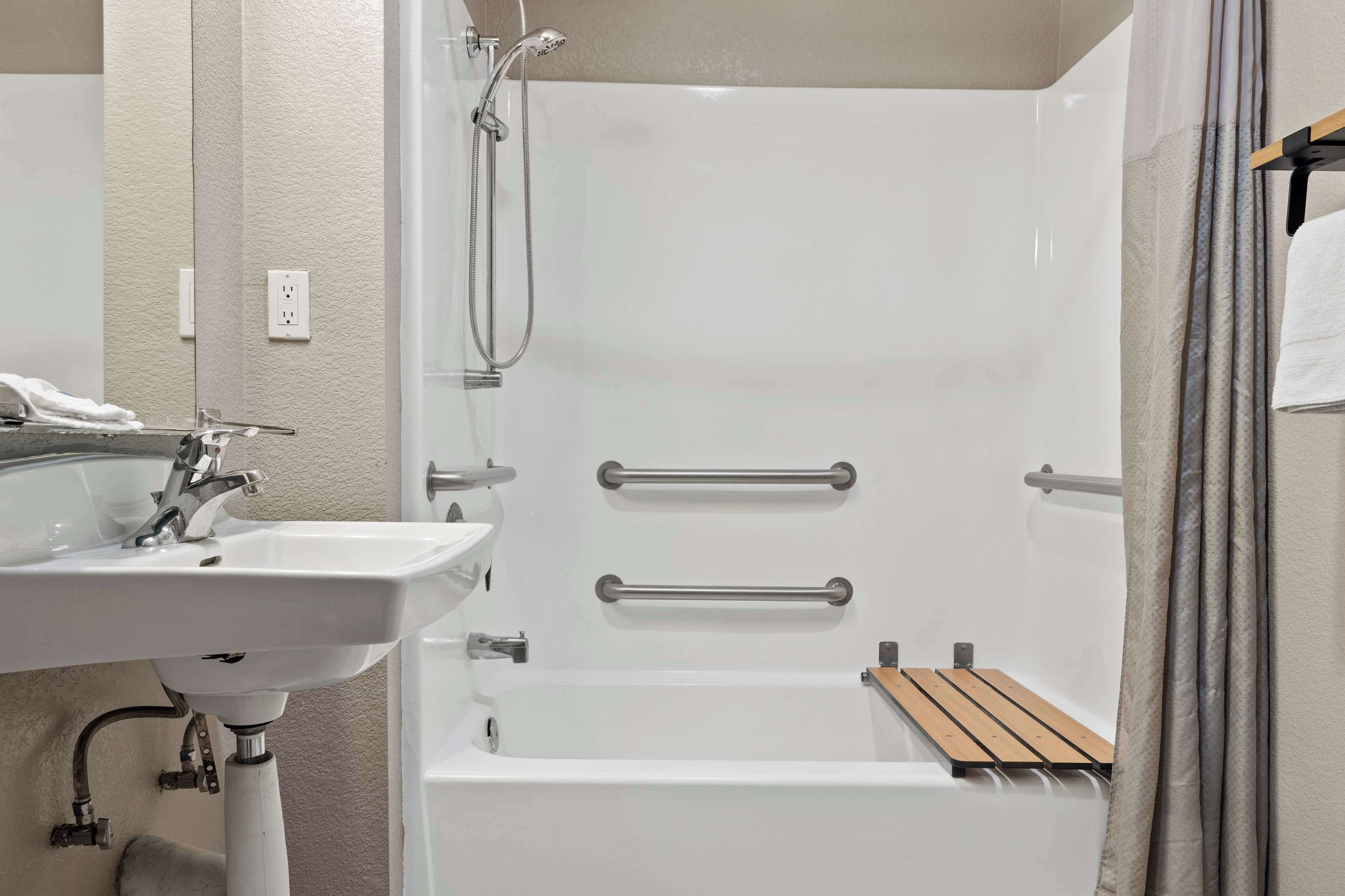 A bathroom with a white sink, a bathtub, and a shower.