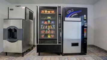 Un refrigerador comercial con dispensador de bebidas y una máquina expendedora.