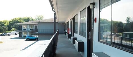 A building with a covered outdoor area, large windows, and a parking lot.