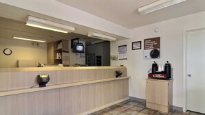 A reception area with a counter, a coffee station, and a clock on the wall. - Motel 6 Gallup, NM (Gallup)