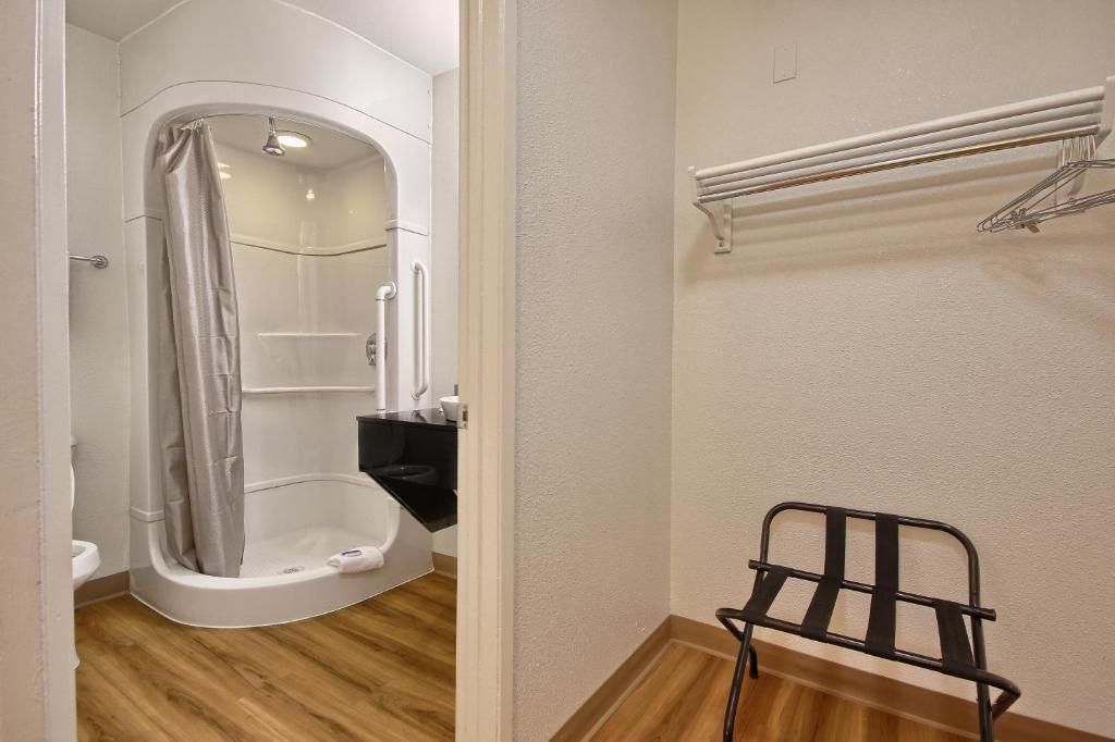 A bathroom with a shower, a toilet, and a towel rack.