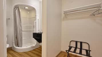 A bathroom with a shower, a toilet, and a towel rack.