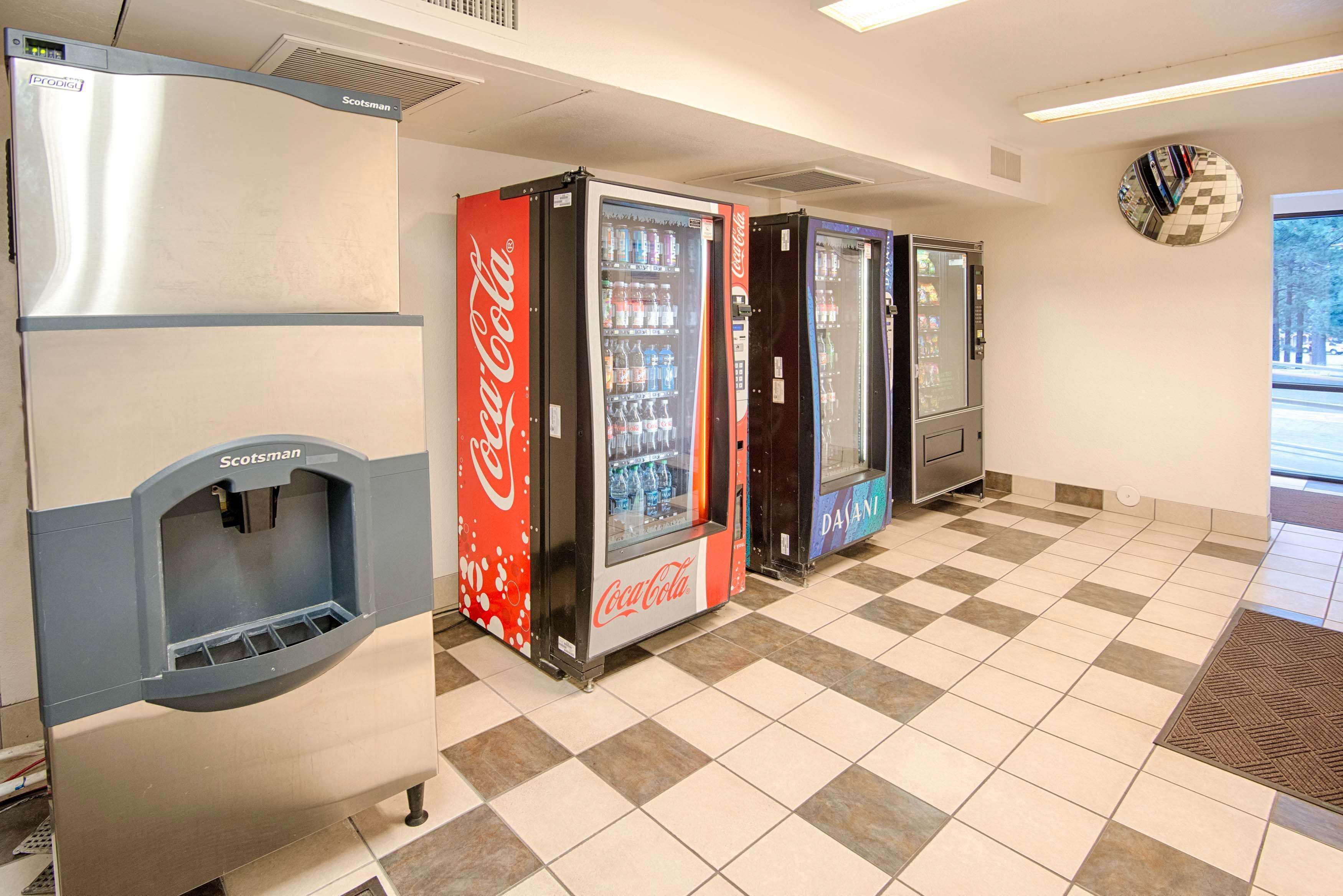 A vending area with Coca-Cola and Pepsi machines, a water dispenser, and a clock on the wall.