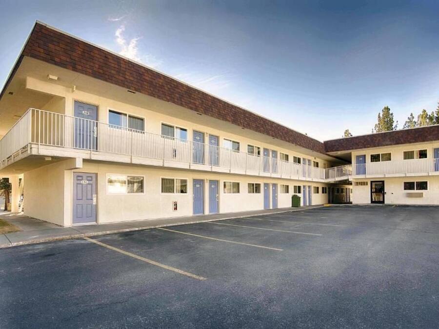 A motel with a central courtyard, individual rooms with balconies, and a parking lot.