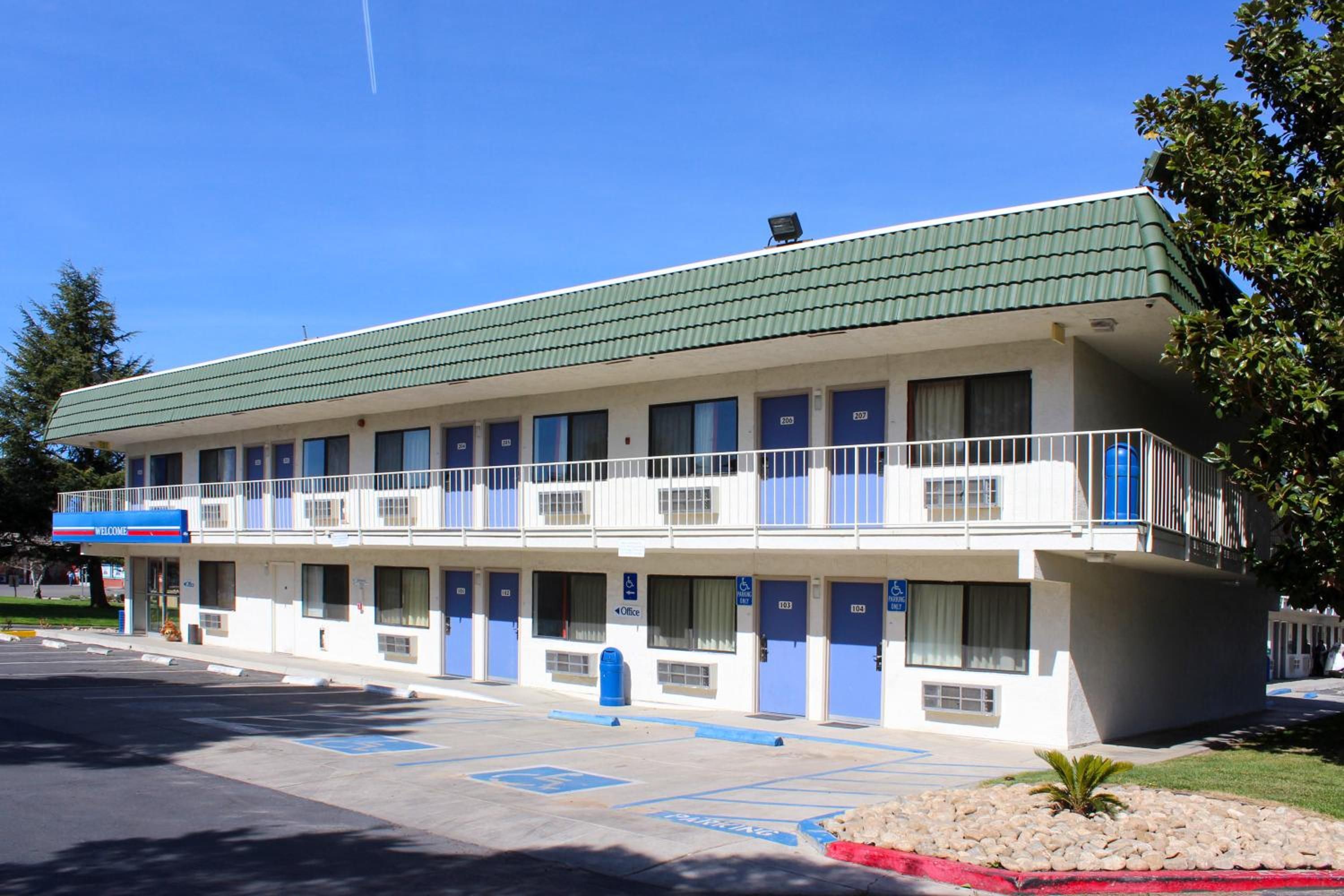 Un motel de dos pisos, con varias habitaciones y un estacionamiento.