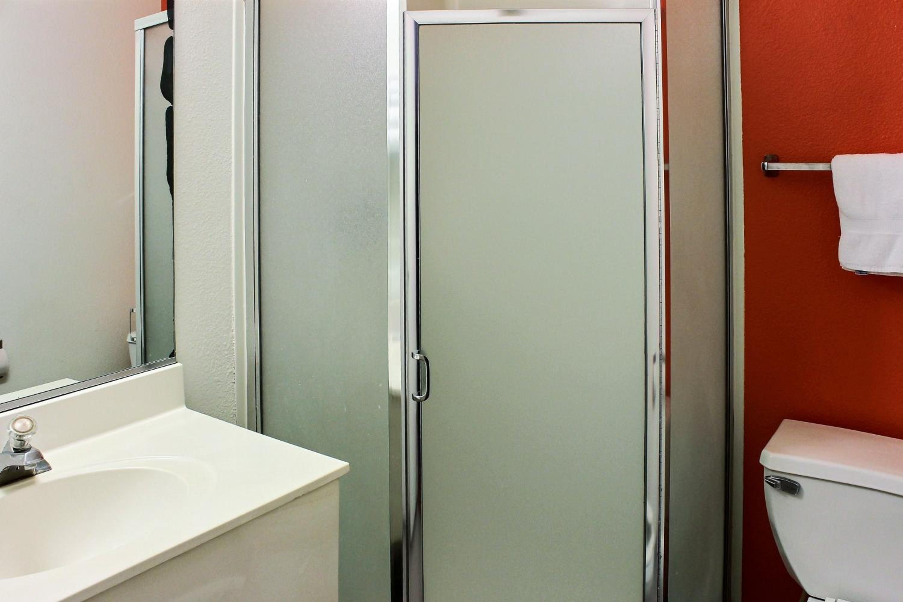 A bathroom with a white sink, a glass shower enclosure, and a toilet.