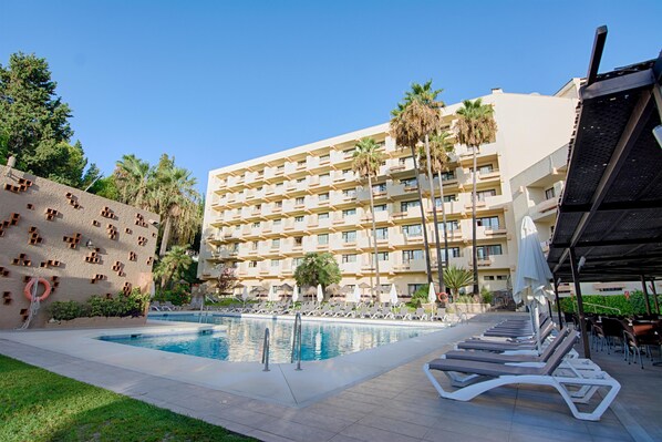A hotel with a swimming pool, lounge chairs, and palm trees. - BLUESEA Al Andalus (Torremolinos)