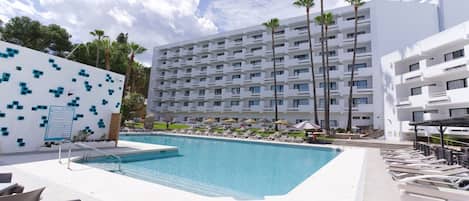 Een buitenzwembad, parasols bij het zwembad en ligstoelen