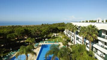 Alberca al aire libre, sombrillas en la alberca y camastros