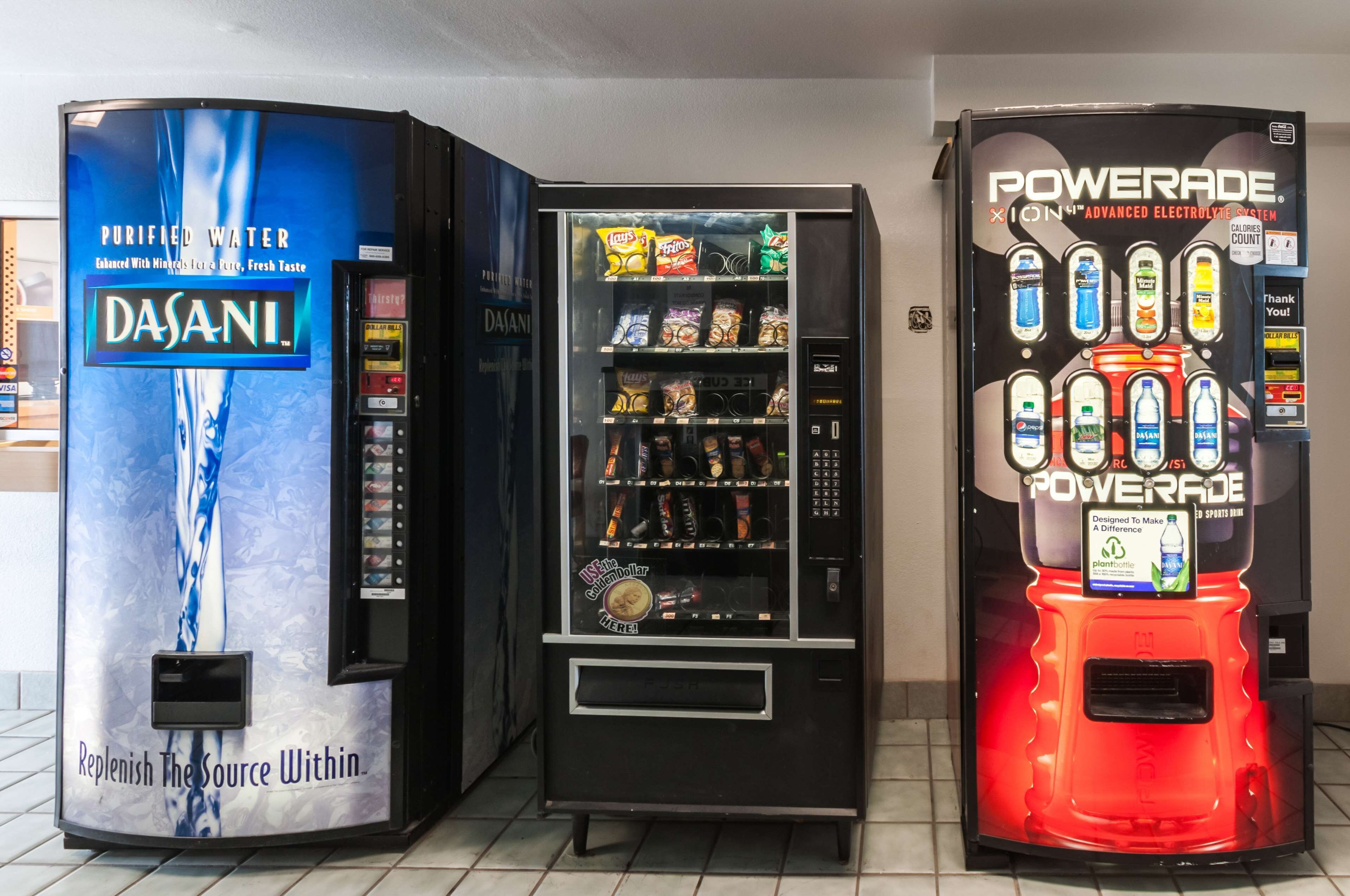 Three beverage vending machines: Dasani, a water dispenser; a snack vending machine; and a Powerade sports drink dispenser.