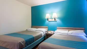 A hotel room with two single beds, a nightstand with a phone, and wall-mounted lamps.