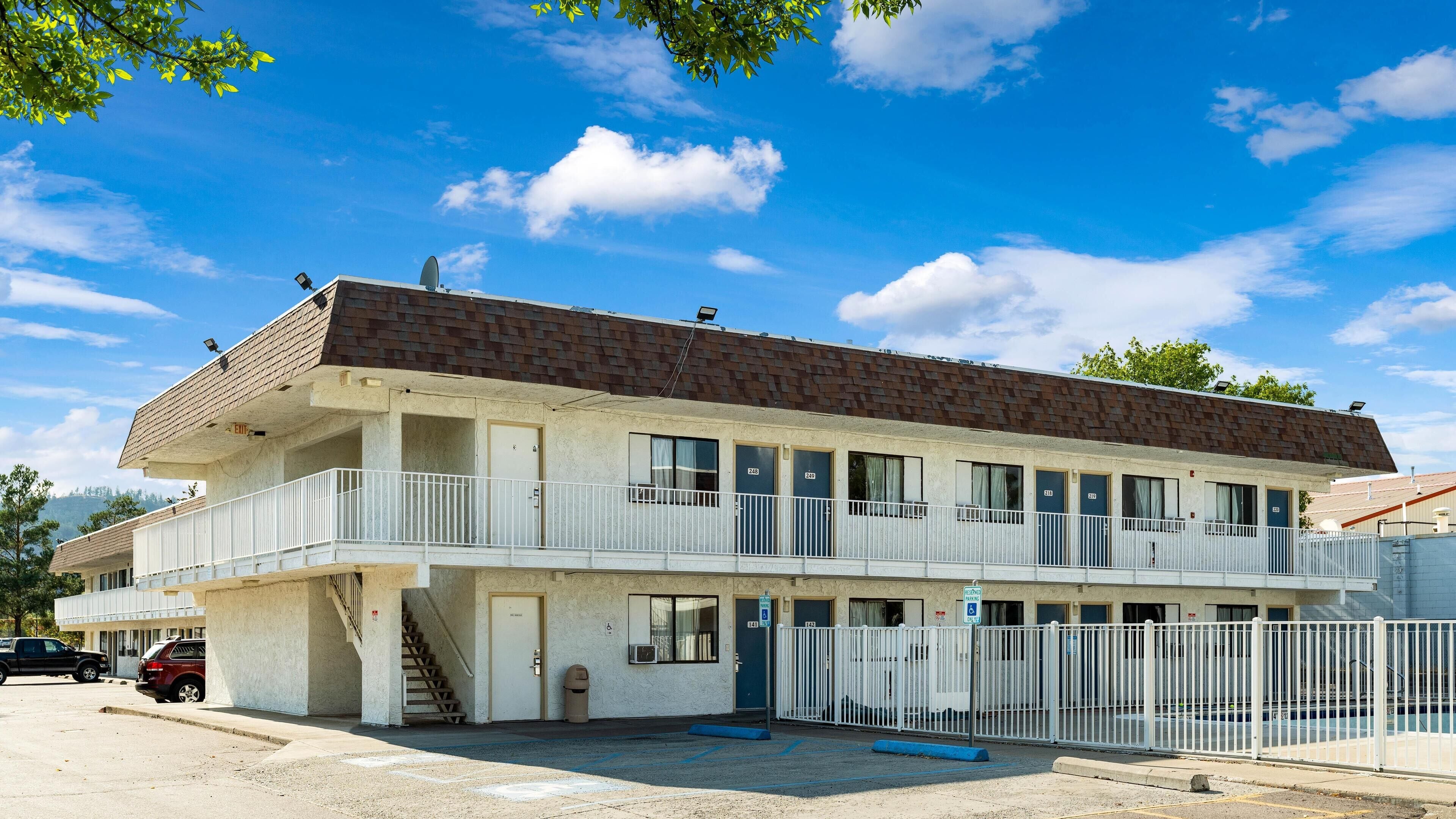 Un motel à deux étages, doté d’un toit plat, de nombreuses chambres et d’un parking clôturé.