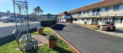 A parking lot with a paved walkway, a white van, and a building with a 'Welcome' sign.