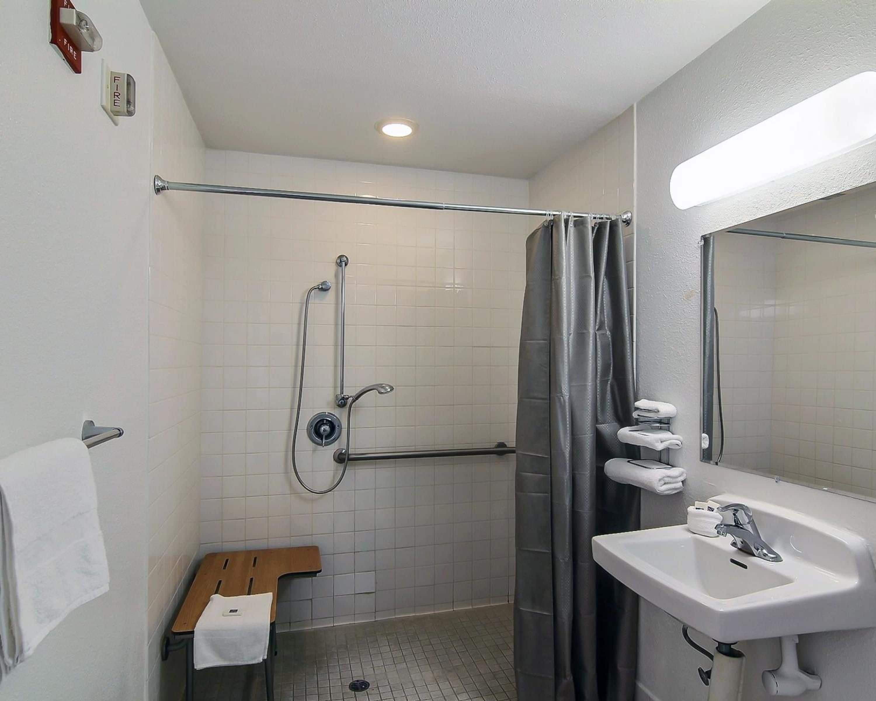 A bathroom with a shower, a toilet, a sink, and a towel rack.