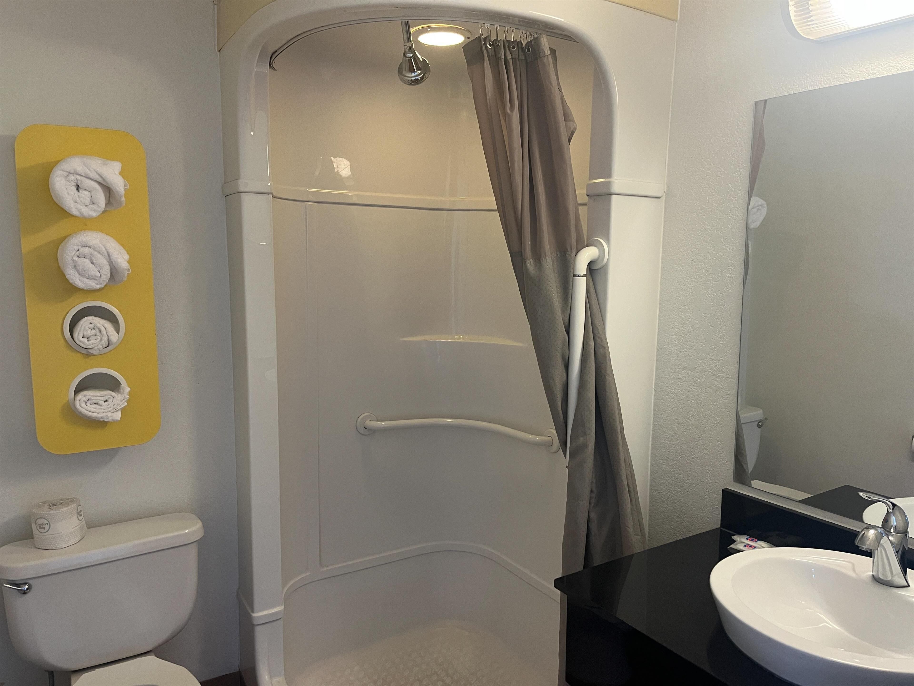 A bathroom with a shower, toilet, and sink.