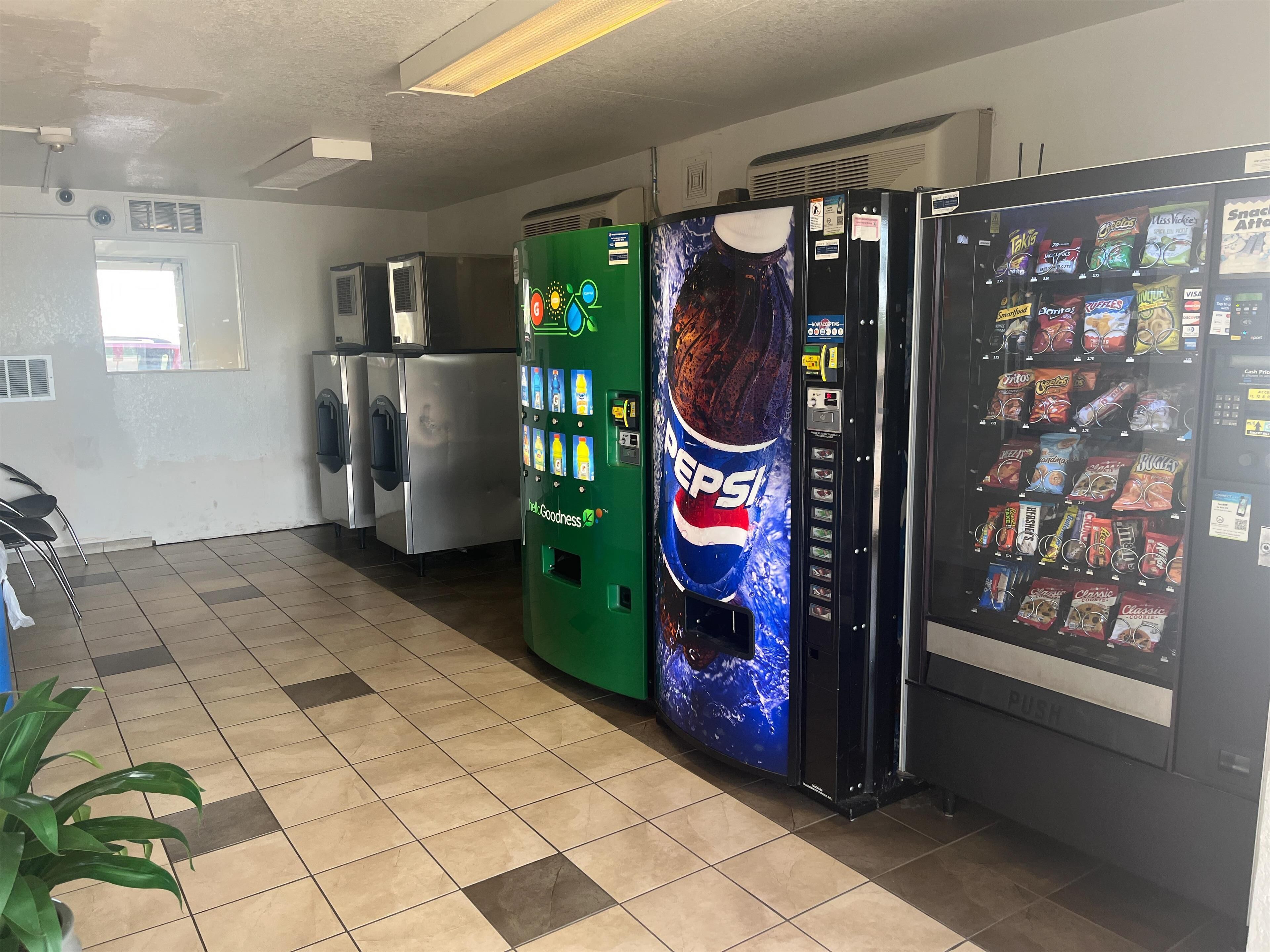 A vending machine area with a Pepsi dispenser, a green vending machine, and a snack vending machine.