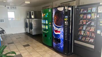 A vending machine area with a Pepsi dispenser, a green vending machine, and a snack vending machine.