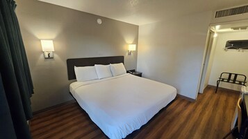 Cortinas opacas, tabla de planchar con plancha, ropa de cama